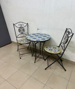A three-piece black wrought-iron table and chair set, featuring blue and yellow ceramic mosaic tile accents on the round tabletop and the seats of the foldable chairs. - Image 10