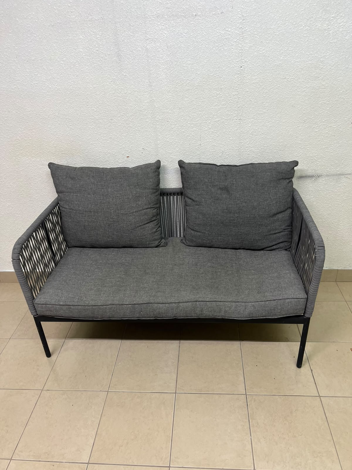 The two-seater outdoor sofa is a modern piece featuring a grey rope-woven design, a black metal frame, and matching back cushions. - Image 3