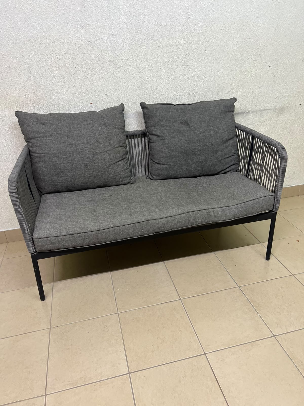 The two-seater outdoor sofa is a modern piece featuring a grey rope-woven design, a black metal frame, and matching back cushions. - Image 5