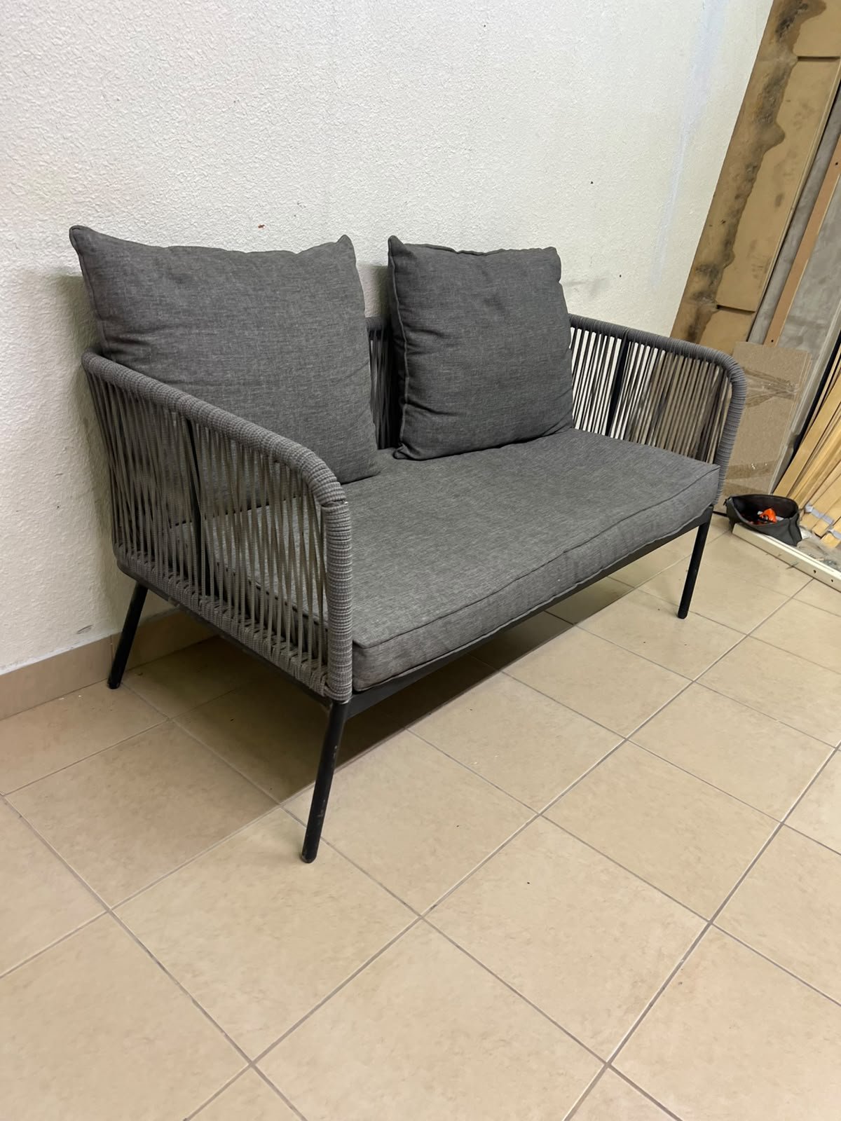 The two-seater outdoor sofa is a modern piece featuring a grey rope-woven design, a black metal frame, and matching back cushions. - Image 8