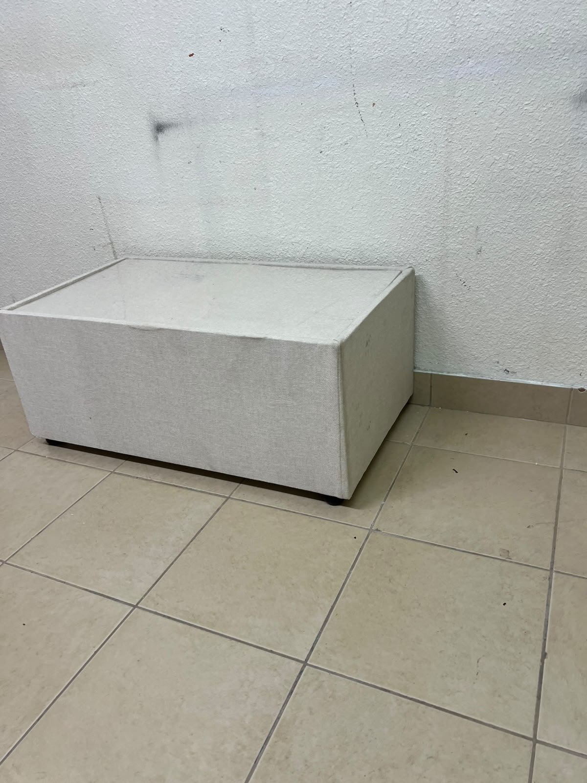 A coffee table upholstered in beige fabric with a textured feel and a neutral, linen-like appearance. - Image 10