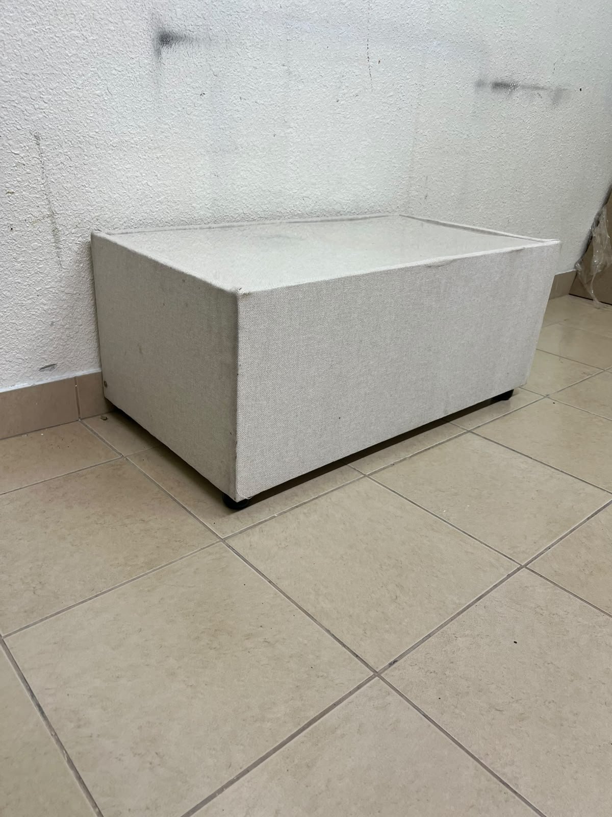 A coffee table upholstered in beige fabric with a textured feel and a neutral, linen-like appearance. - Image 4