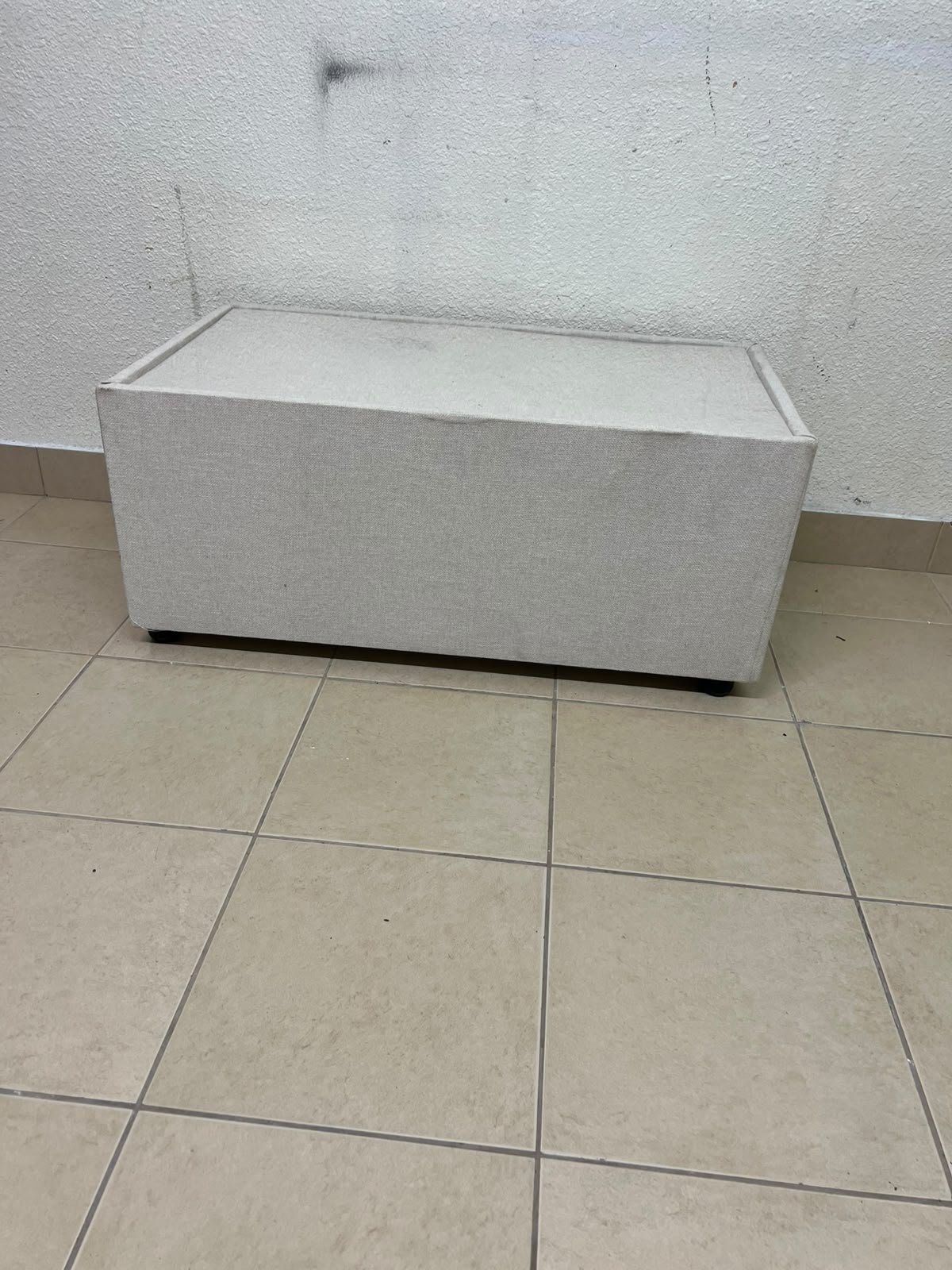 A coffee table upholstered in beige fabric with a textured feel and a neutral, linen-like appearance. - Image 5