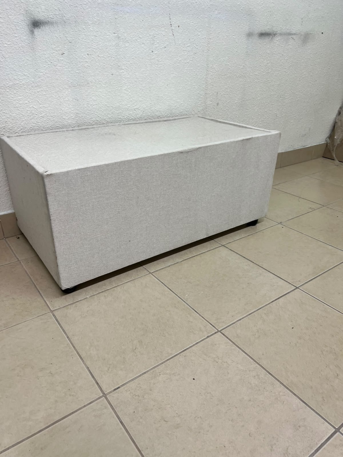 A coffee table upholstered in beige fabric with a textured feel and a neutral, linen-like appearance. - Image 7
