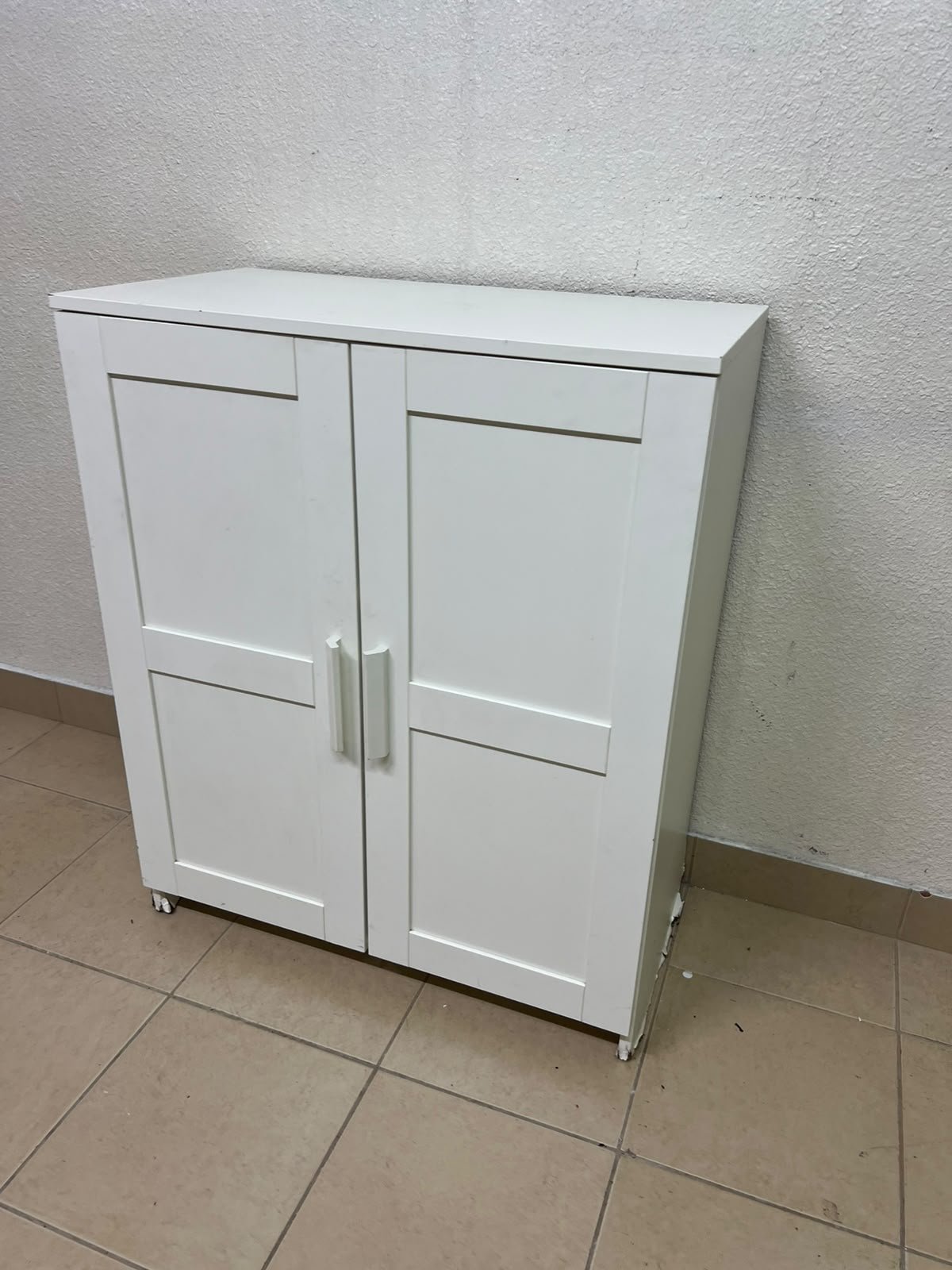 The white IKEA BRIMNES wardrobe features an elegant design with double paneled doors. - Image 4