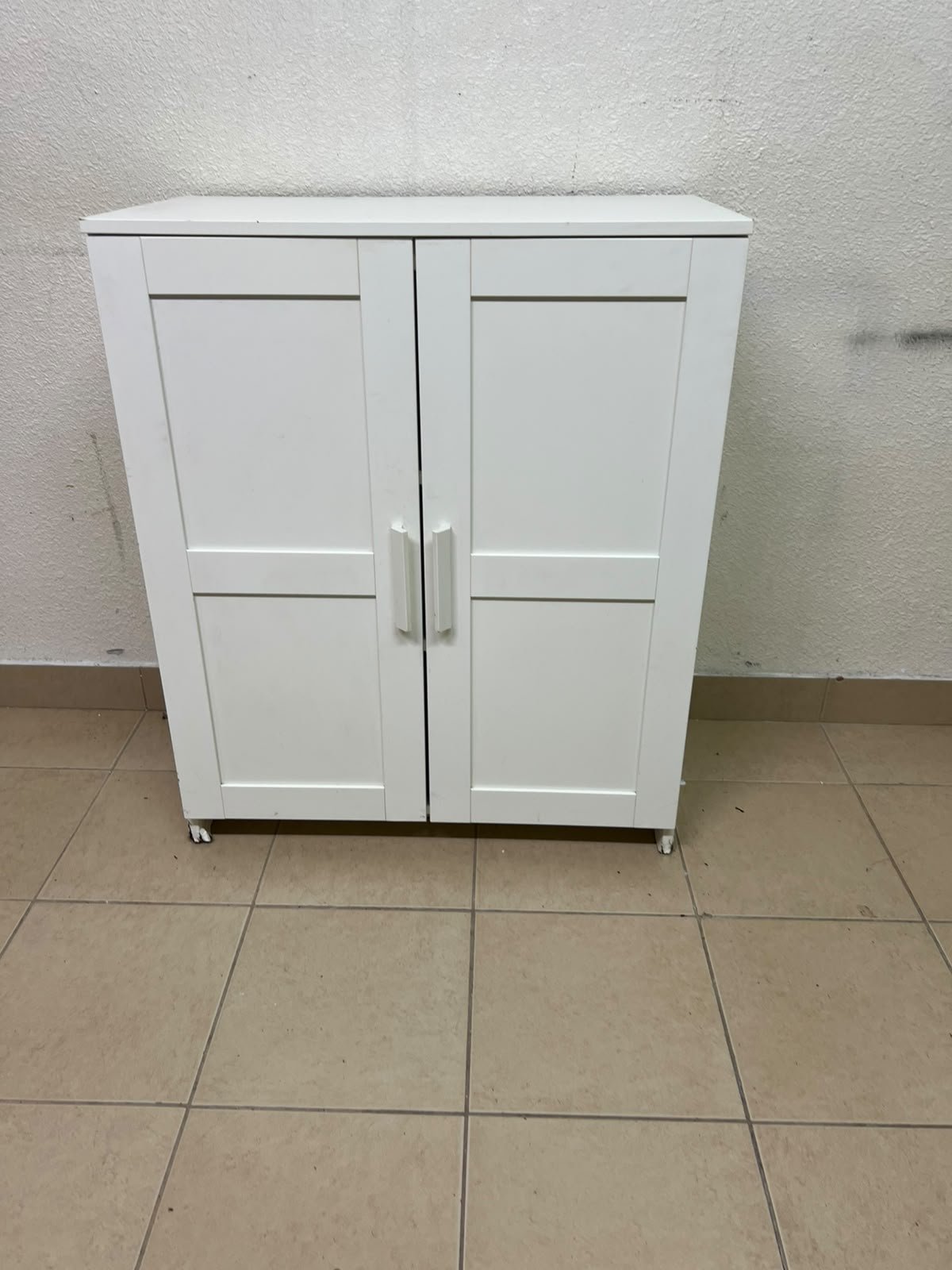 The white IKEA BRIMNES wardrobe features an elegant design with double paneled doors.