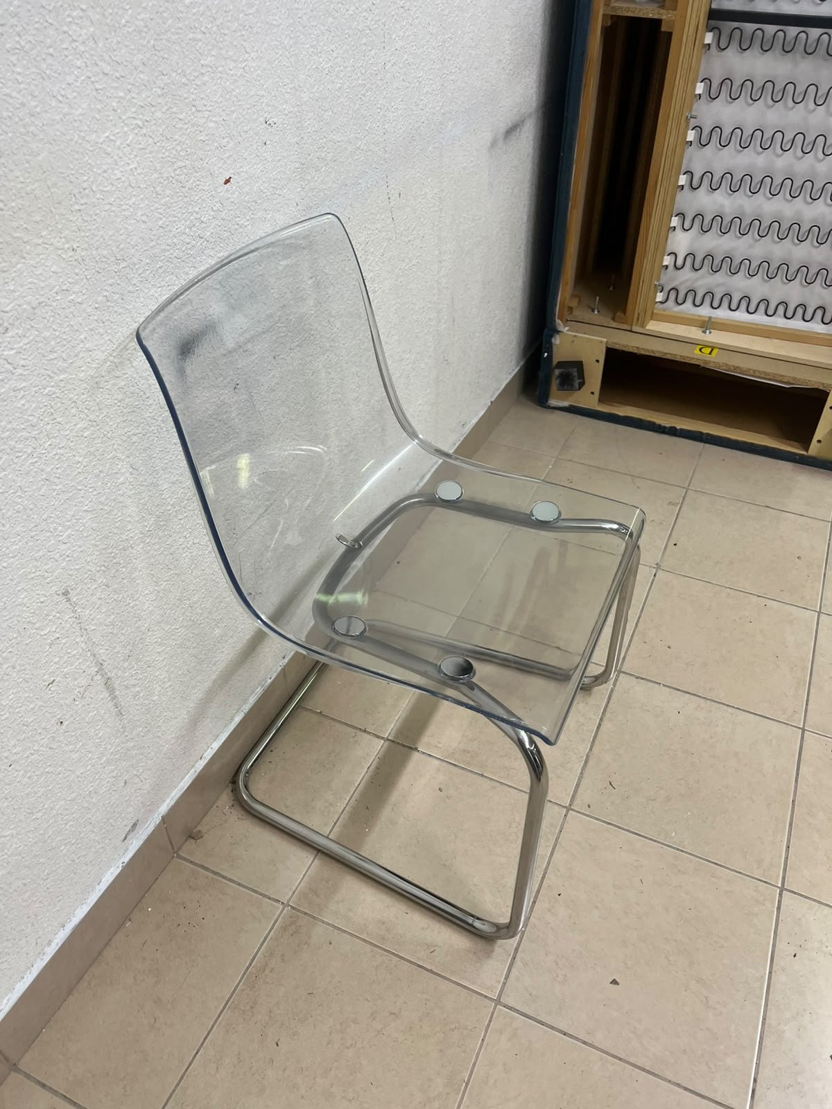 The IKEA "Tobias" chair, featuring a transparent acrylic seat and a chrome-plated steel frame.
