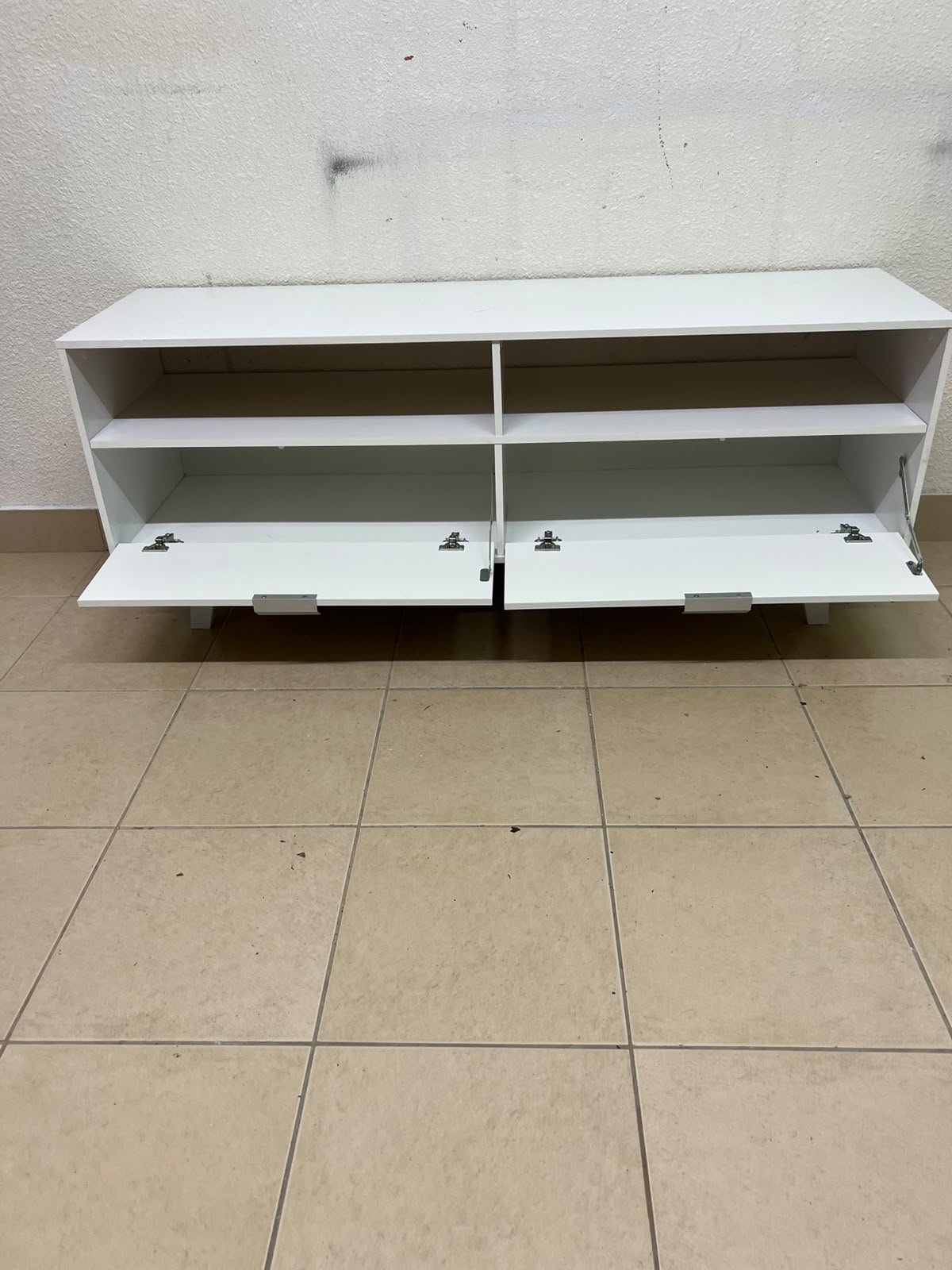 A modern, white, freestanding TV stand featuring angled legs and two large lower storage drawers, topped by open shelves. - Image 5