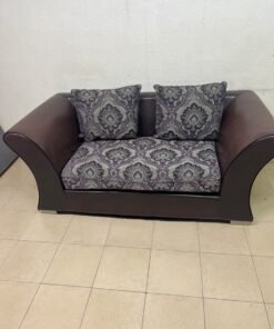 The sofa is designed for two people and upholstered in dark brown faux leather, with a purple and gray damask-patterned fabric covering the seat cushions and matching throw pillows. - Image 6