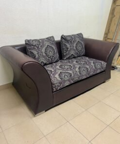 The sofa is designed for two people and upholstered in dark brown faux leather, with a purple and gray damask-patterned fabric covering the seat cushions and matching throw pillows. - Image 7