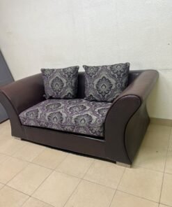 The sofa is designed for two people and upholstered in dark brown faux leather, with a purple and gray damask-patterned fabric covering the seat cushions and matching throw pillows. - Image 8