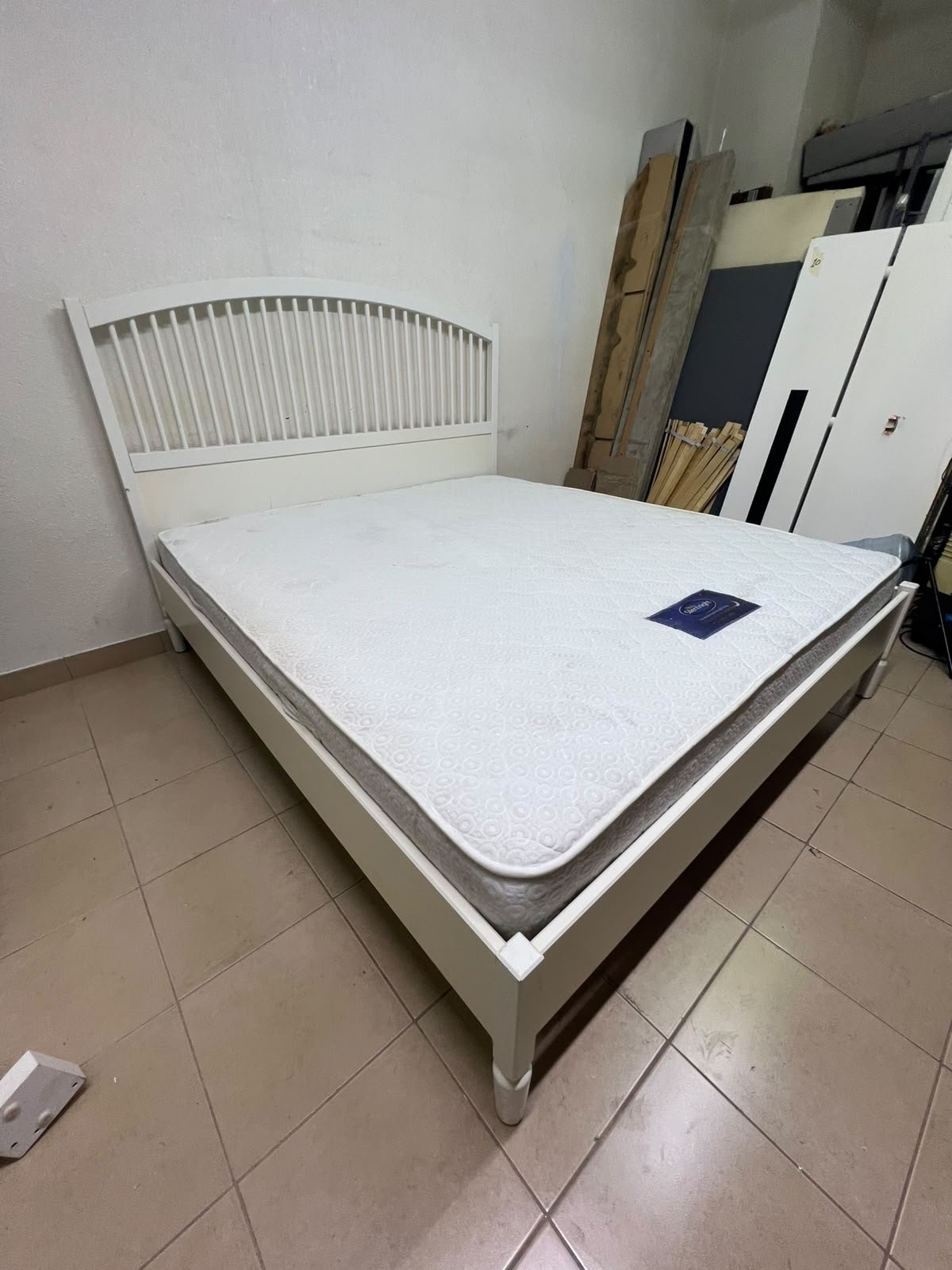 The white IKEA TYSSEDAL bed frame, featuring distinctive vertical wooden slats on the arched headboard and carved legs.