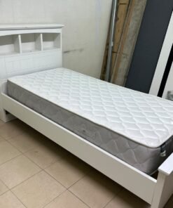 A white wooden single bed frame featuring a headboard with built-in bookshelves, and equipped with a standard padded mattress. - Image 2