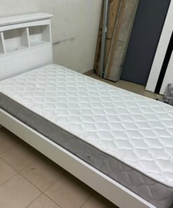 A white wooden single bed frame featuring a headboard with built-in bookshelves, and equipped with a standard padded mattress. - Image 3