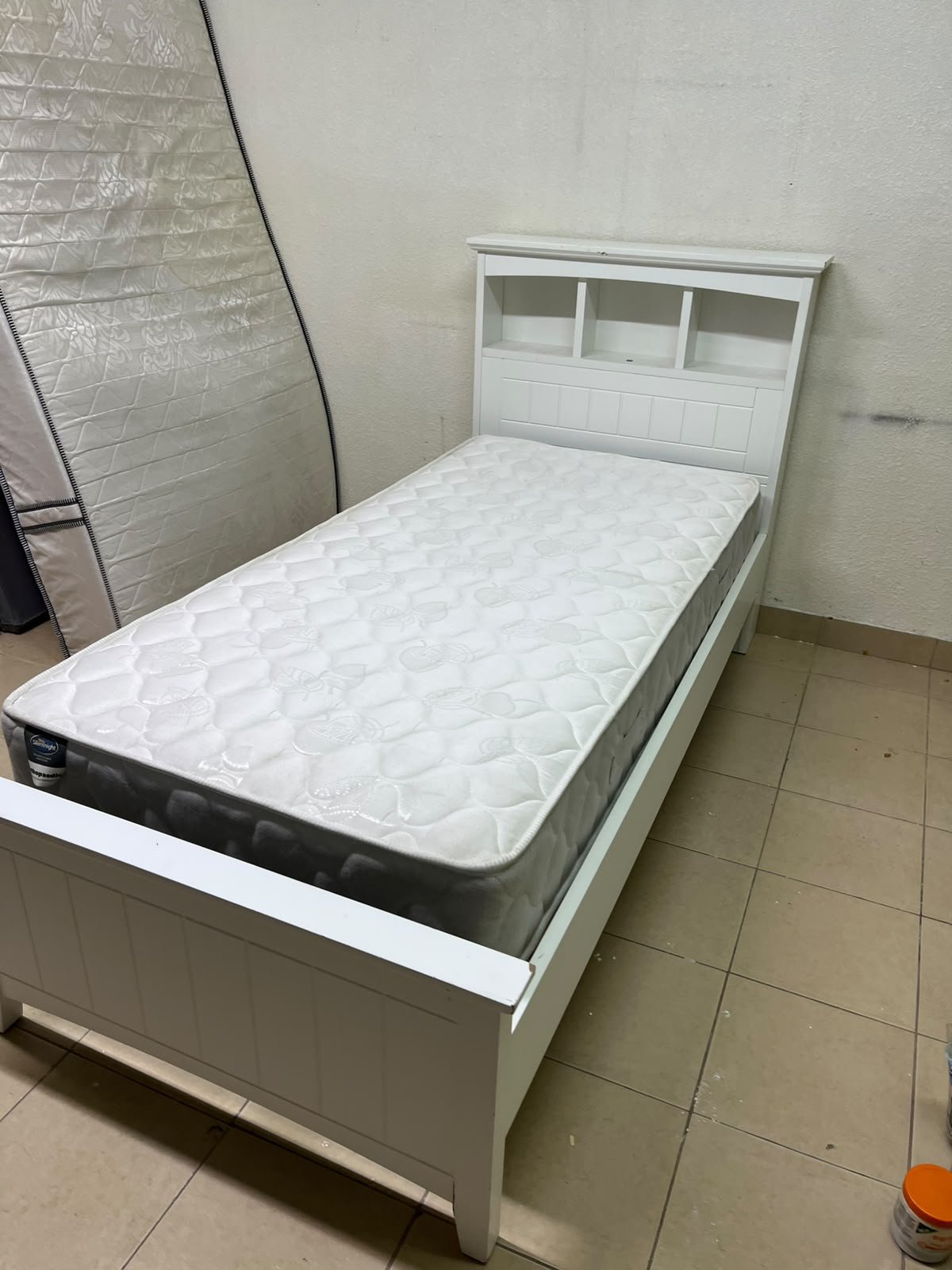 A white wooden single bed frame featuring a headboard with built-in bookshelves, and equipped with a standard padded mattress. - Image 13