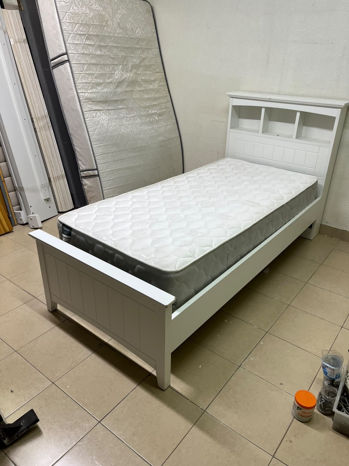 A white wooden single bed frame featuring a headboard with built-in bookshelves, and equipped with a standard padded mattress. - Image 8