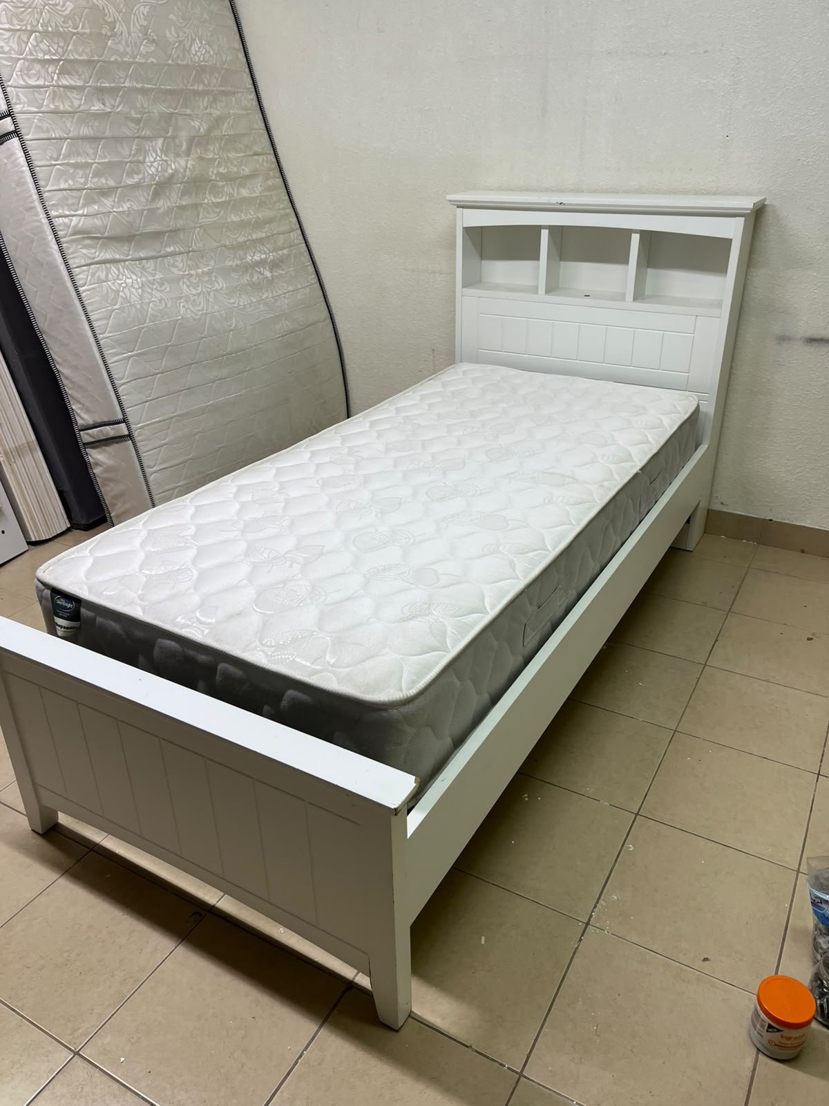 A white wooden single bed frame featuring a headboard with built-in bookshelves, and equipped with a standard padded mattress. - Image 6
