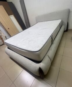 A modern, curved bed frame upholstered in off-white bouclé fabric with dark wood accents, complemented by a patterned, cushioned mattress. - Image 5
