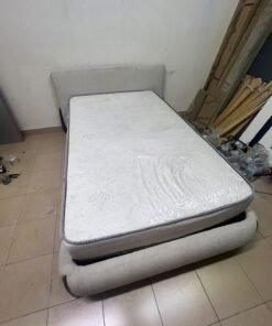 A modern, curved bed frame upholstered in off-white bouclé fabric with dark wood accents, complemented by a patterned, cushioned mattress. - Image 7
