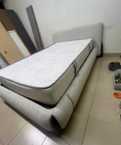 A modern, curved bed frame upholstered in off-white bouclé fabric with dark wood accents, complemented by a patterned, cushioned mattress. - Image 9