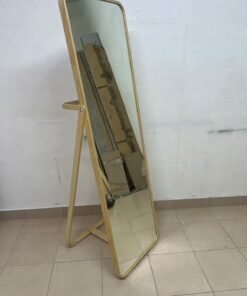 The IKEA IKORNNES ash wood standing mirror, featuring a distinctive rounded wooden frame and a hanging rail integrated into the rear stand.