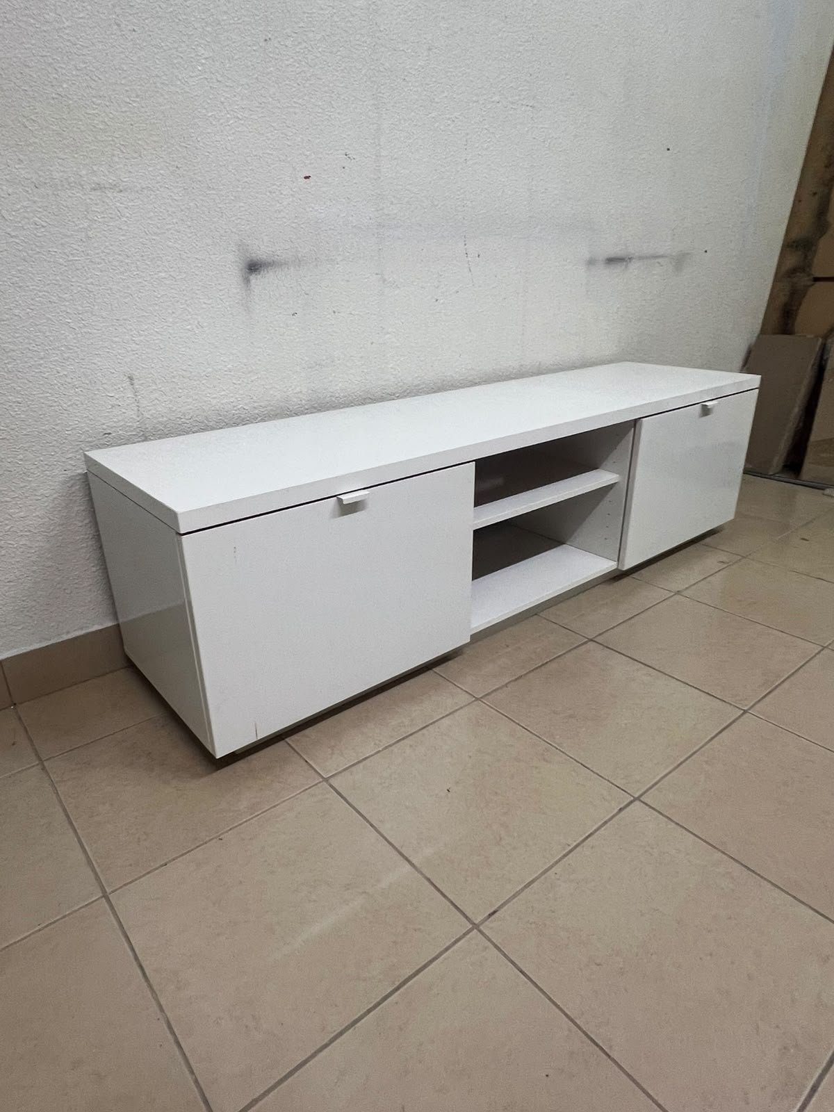 The IKEA BYÅS TV unit in high-gloss white features a sleek, modern design with two cabinets and open central shelves.