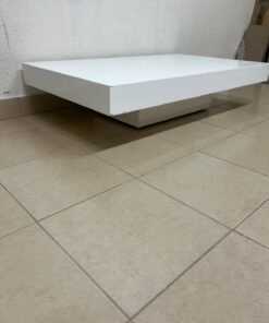 A modern, low, rectangular white coffee table featuring a minimalist design, a recessed base, and a smooth lacquered finish.