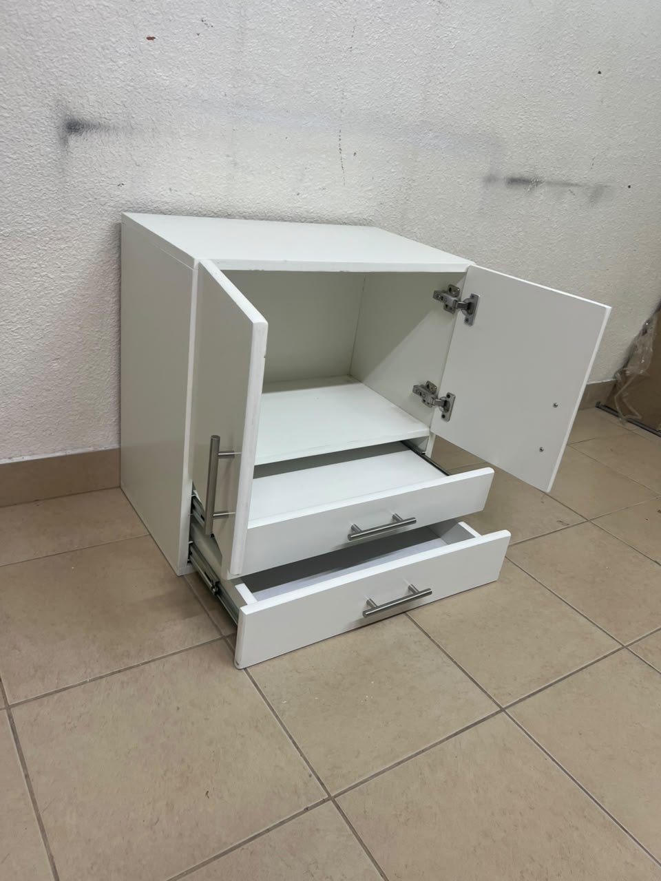 A white wooden storage cabinet featuring two upper doors and two lower drawers equipped with rectangular silver handles. - Image 3