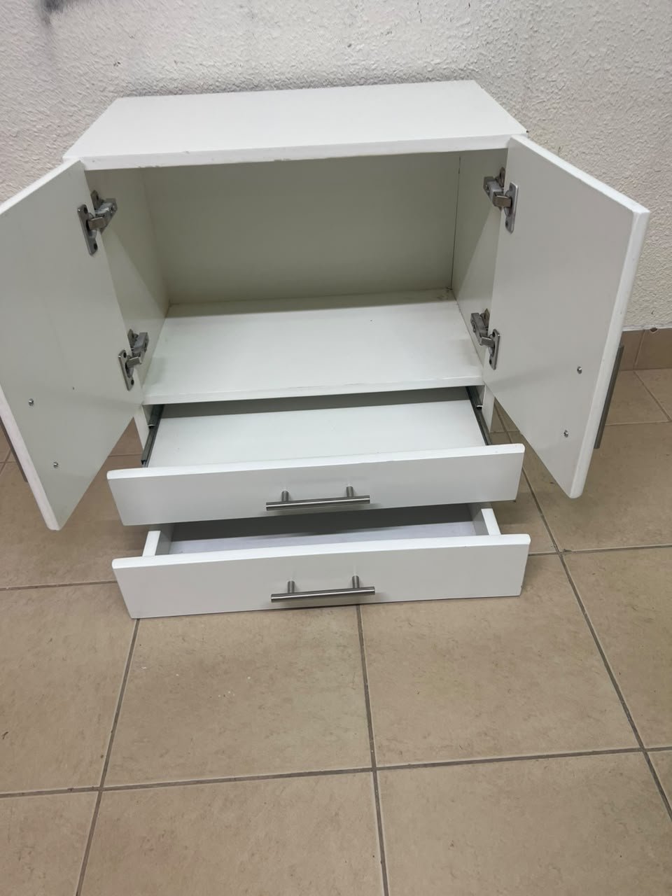 A white wooden storage cabinet featuring two upper doors and two lower drawers equipped with rectangular silver handles. - Image 12