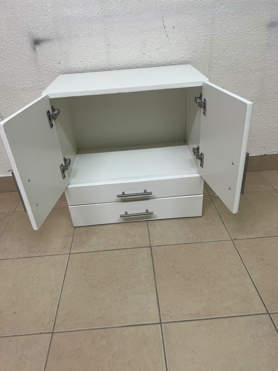 A white wooden storage cabinet featuring two upper doors and two lower drawers equipped with rectangular silver handles. - Image 11