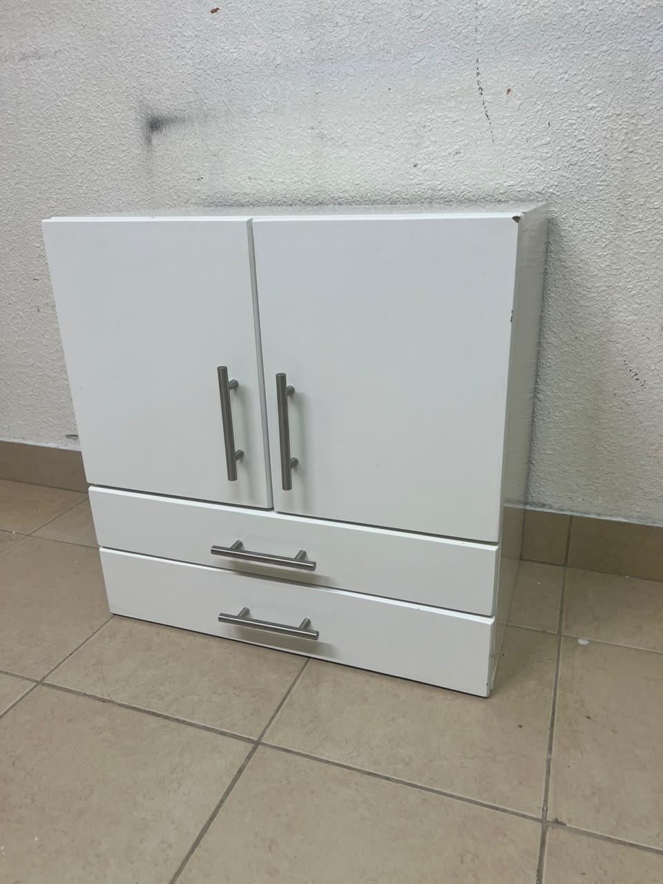 A white wooden storage cabinet featuring two upper doors and two lower drawers equipped with rectangular silver handles. - Image 10