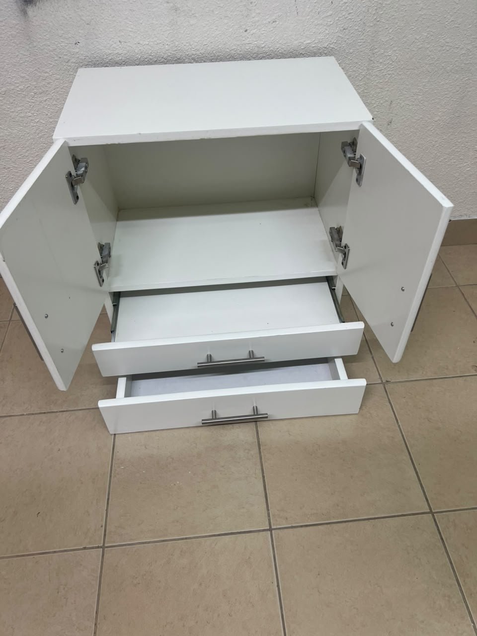 A white wooden storage cabinet featuring two upper doors and two lower drawers equipped with rectangular silver handles. - Image 9