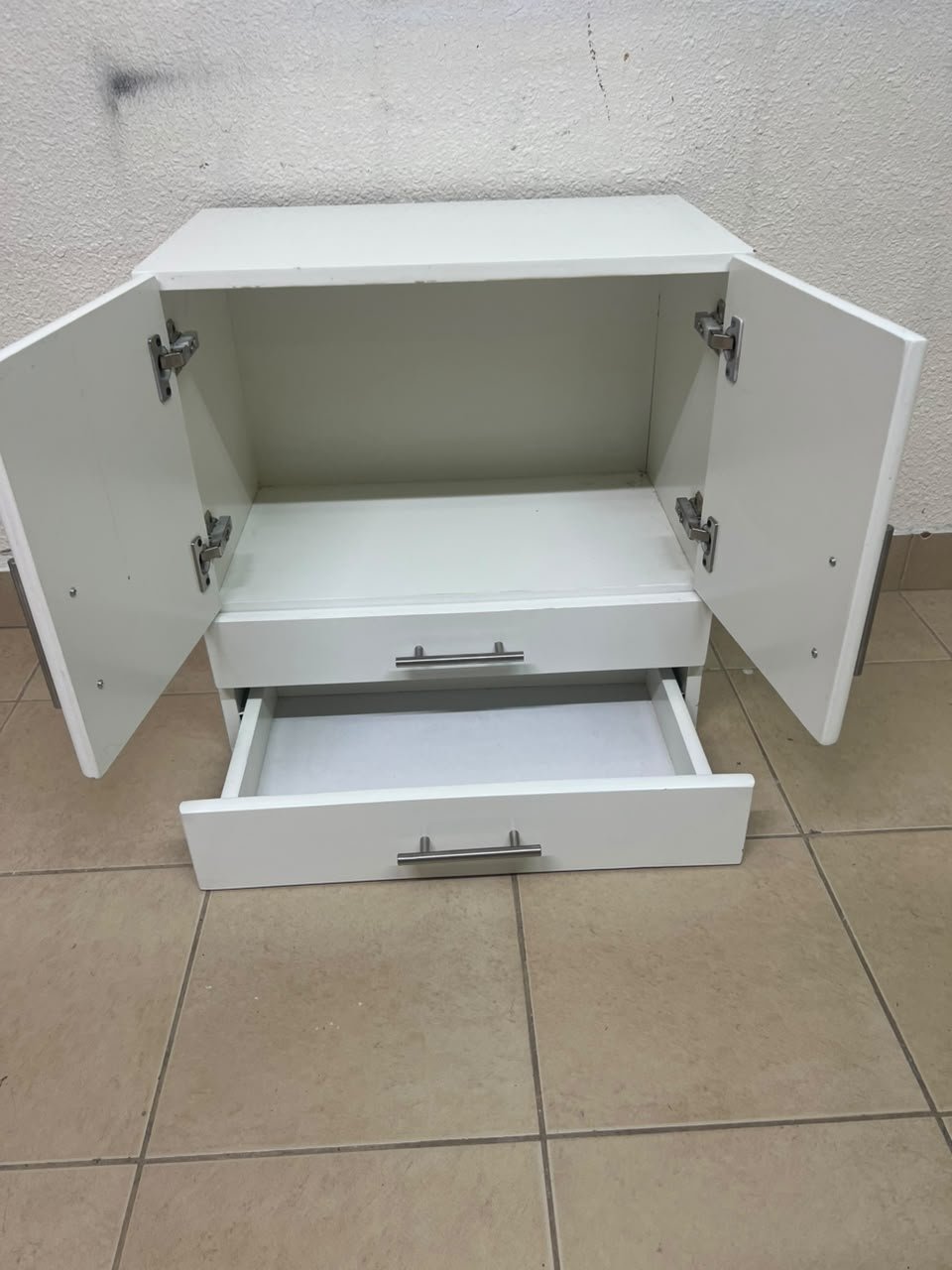A white wooden storage cabinet featuring two upper doors and two lower drawers equipped with rectangular silver handles. - Image 8