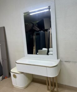 A modern vanity (makeup station) featuring a white striped design, a gold frame, and illuminated accents—a piece of contemporary bedroom décor.