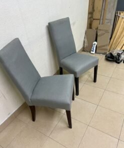 A modern "Parsons" style dining chair, featuring a high back, gray upholstery, and dark wood legs. - Image 7