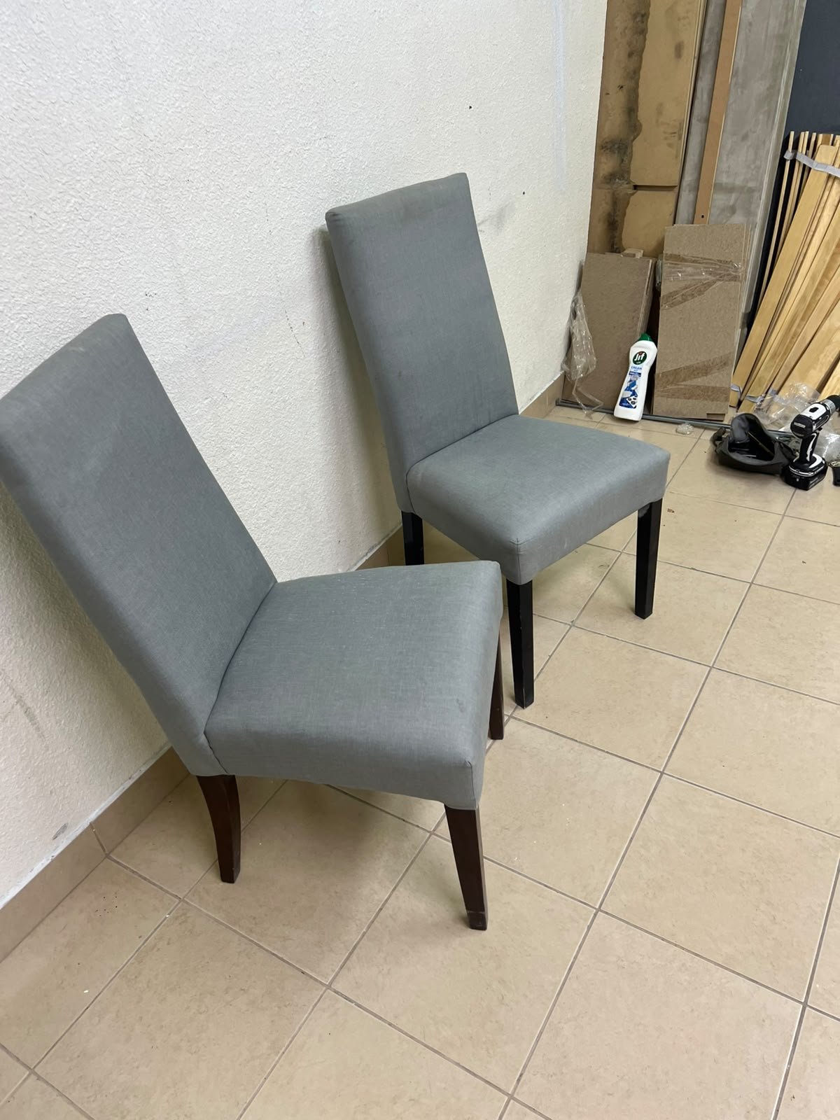 A modern "Parsons" style dining chair, featuring a high back, gray upholstery, and dark wood legs. - Image 7