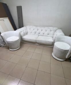 A modern living room furniture set in an off-white or cream hue, featuring a cushioned sofa with a curved back, complemented by matching barrel-style swivel chairs with round bases. - Image 2