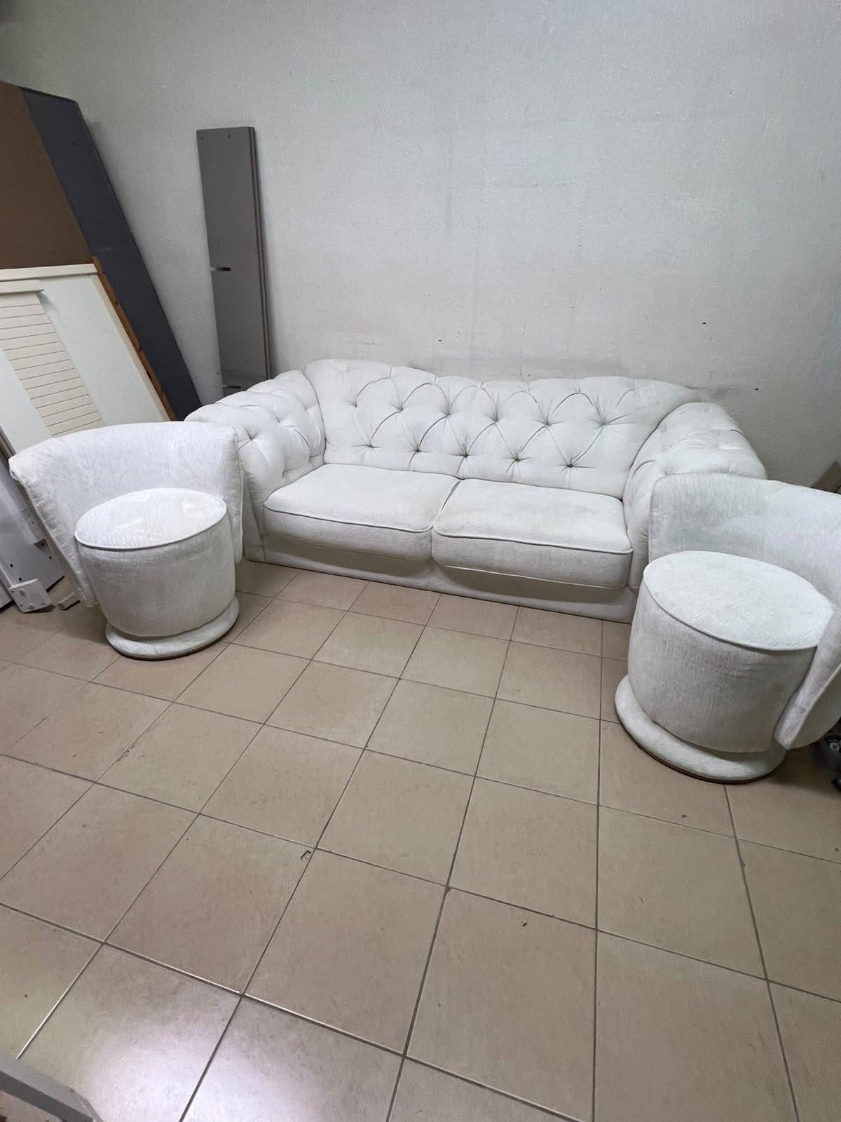 A modern living room furniture set in an off-white or cream hue, featuring a cushioned sofa with a curved back, complemented by matching barrel-style swivel chairs with round bases. - Image 2