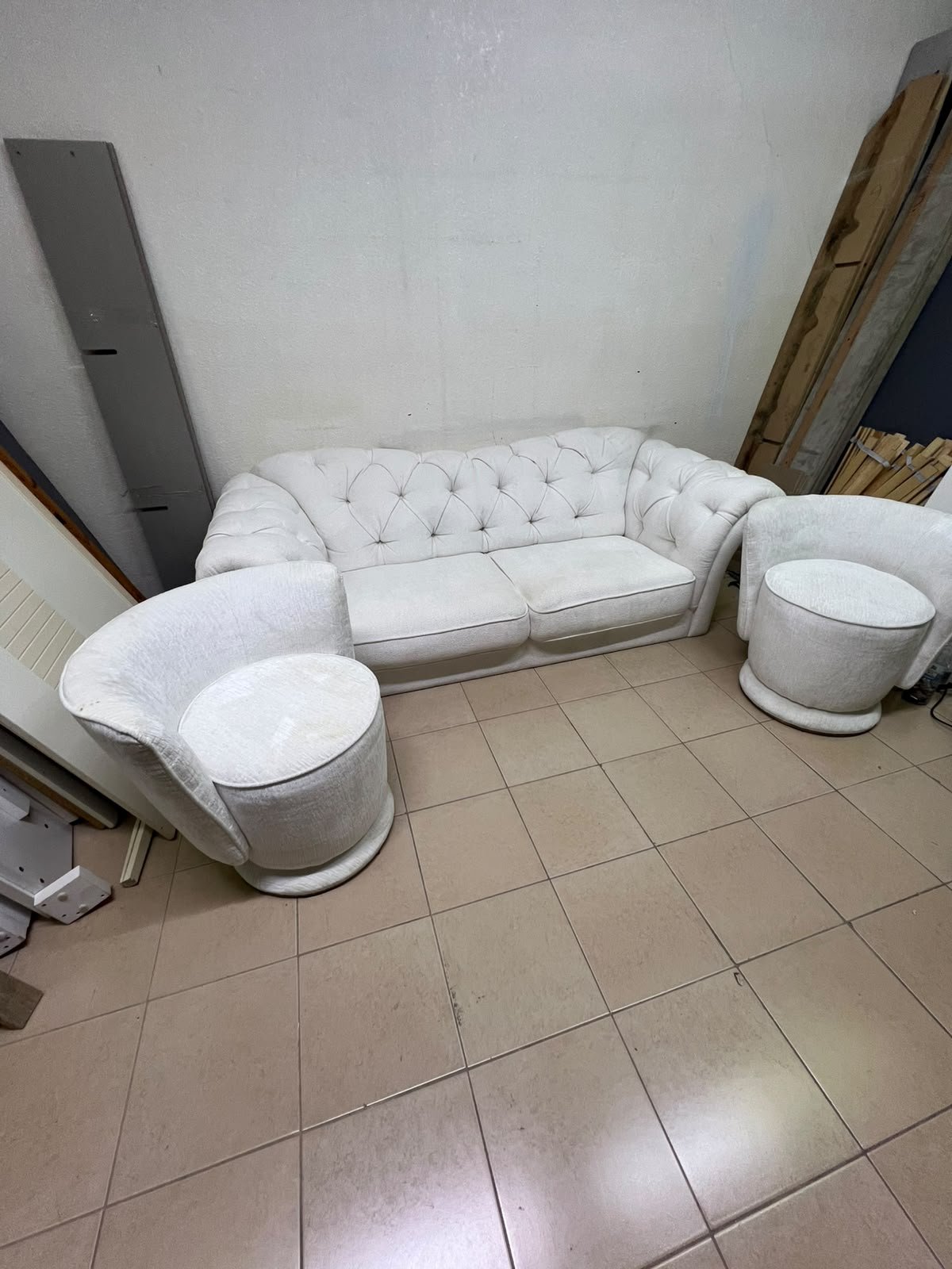 A modern living room furniture set in an off-white or cream hue, featuring a cushioned sofa with a curved back, complemented by matching barrel-style swivel chairs with round bases. - Image 4