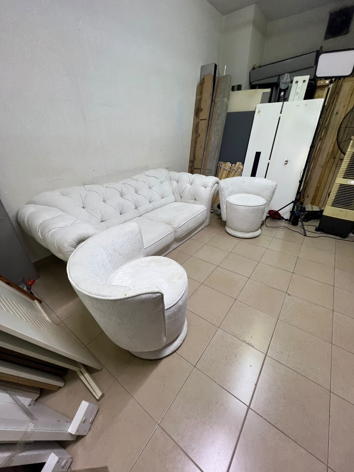 A modern living room furniture set in an off-white or cream hue, featuring a cushioned sofa with a curved back, complemented by matching barrel-style swivel chairs with round bases. - Image 5