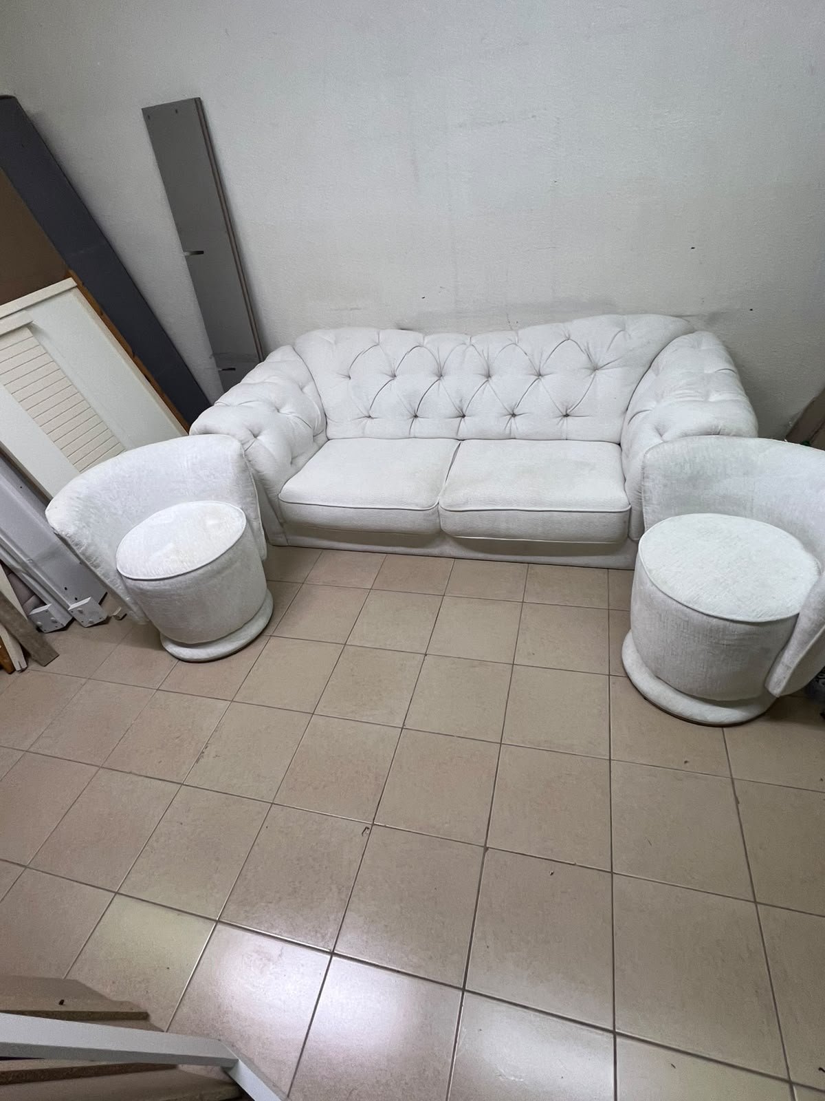 A modern living room furniture set in an off-white or cream hue, featuring a cushioned sofa with a curved back, complemented by matching barrel-style swivel chairs with round bases. - Image 6