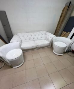 A modern living room furniture set in an off-white or cream hue, featuring a cushioned sofa with a curved back, complemented by matching barrel-style swivel chairs with round bases. - Image 7