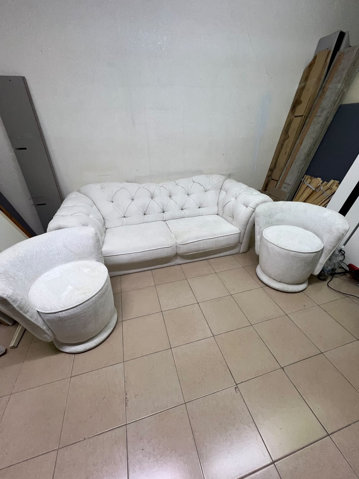 A modern living room furniture set in an off-white or cream hue, featuring a cushioned sofa with a curved back, complemented by matching barrel-style swivel chairs with round bases. - Image 7