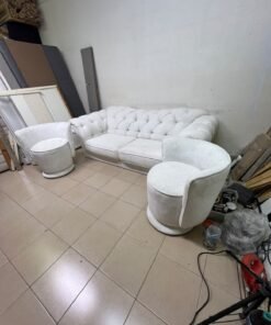 A modern living room furniture set in an off-white or cream hue, featuring a cushioned sofa with a curved back, complemented by matching barrel-style swivel chairs with round bases. - Image 9