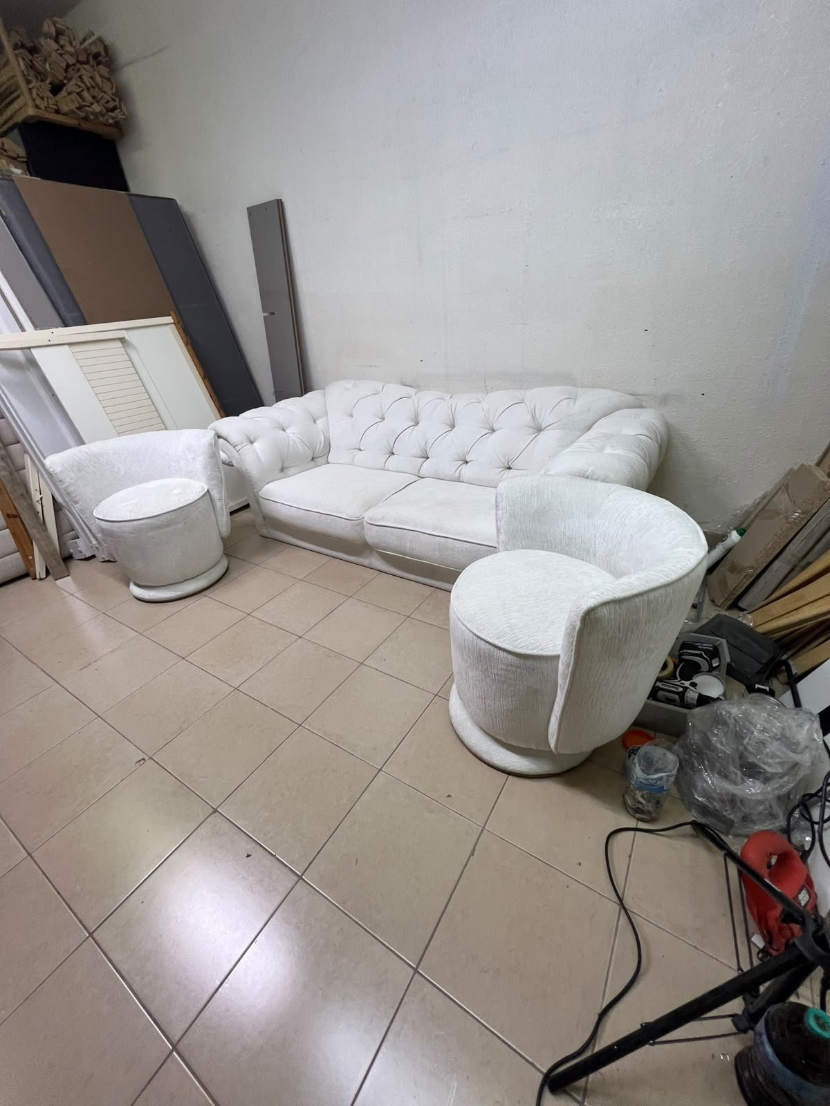 A modern living room furniture set in an off-white or cream hue, featuring a cushioned sofa with a curved back, complemented by matching barrel-style swivel chairs with round bases. - Image 9