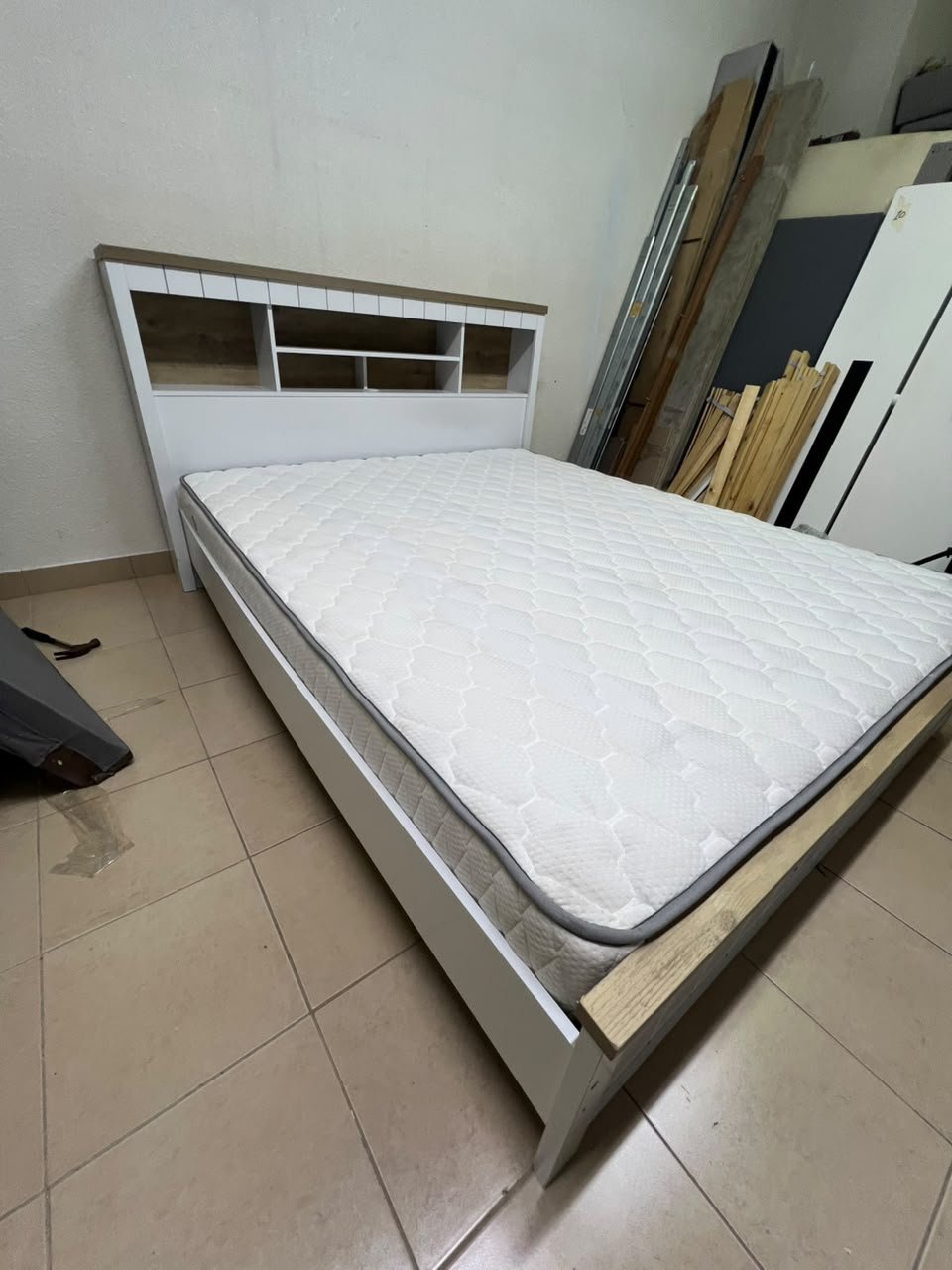 A white wooden King-size bed frame featuring an integrated headboard with shelves, accompanied by a matching padded mattress. - Image 4