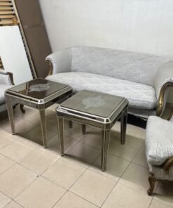 A light-colored, upholstered classic living room set featuring a sofa and armchairs with carved wooden frames, along with two matching mirrored side tables. - Image 2