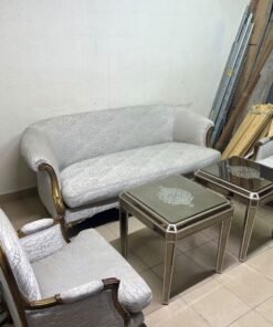 A light-colored, upholstered classic living room set featuring a sofa and armchairs with carved wooden frames, along with two matching mirrored side tables. - Image 3