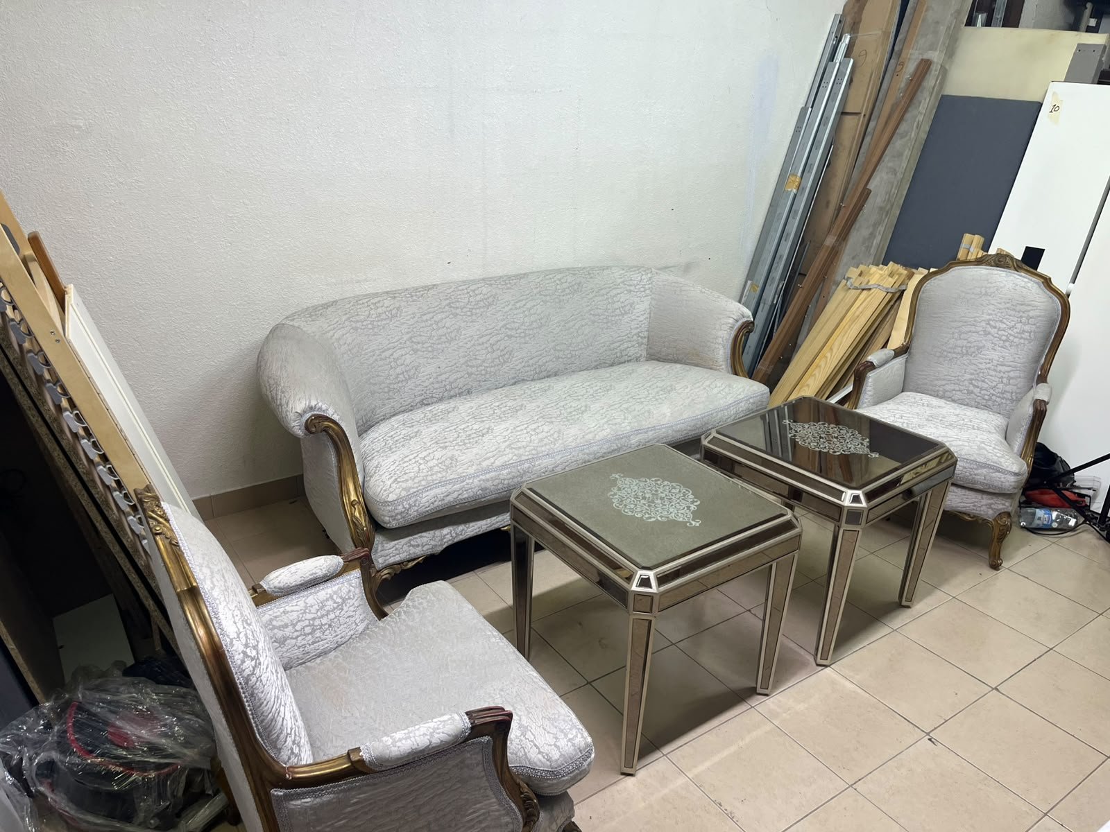 A light-colored, upholstered classic living room set featuring a sofa and armchairs with carved wooden frames, along with two matching mirrored side tables. - Image 3