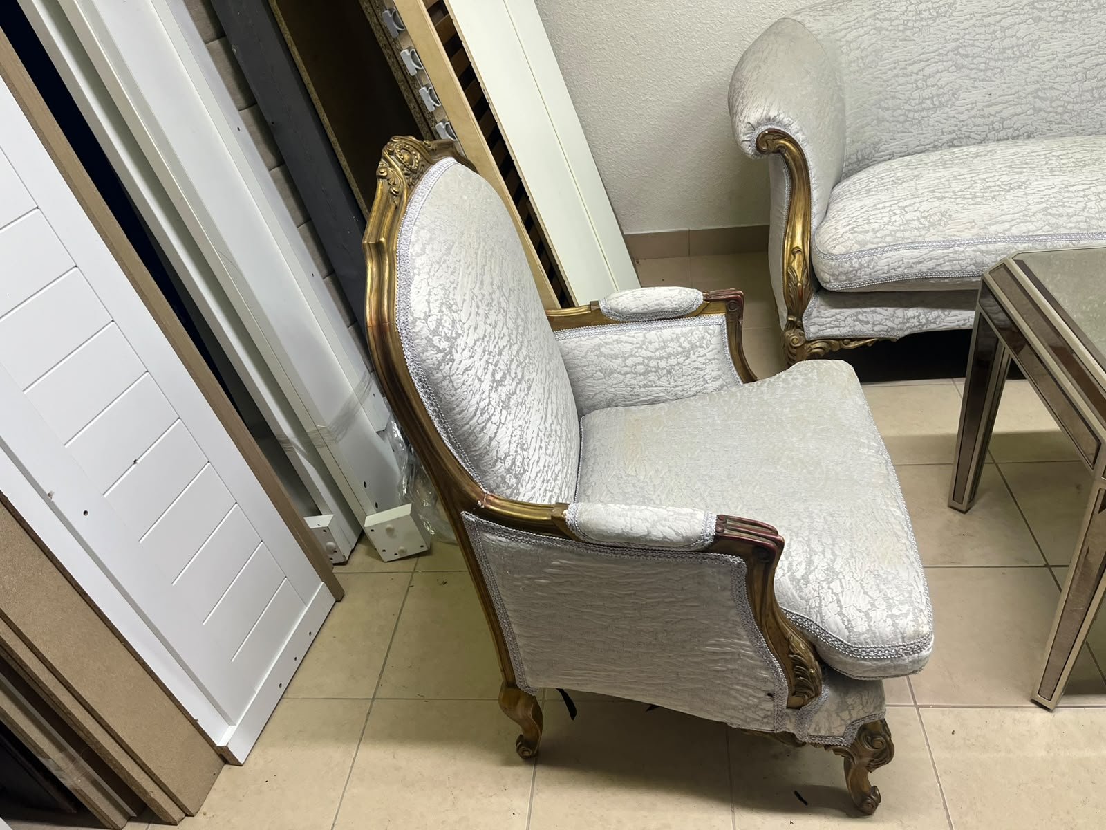 A light-colored, upholstered classic living room set featuring a sofa and armchairs with carved wooden frames, along with two matching mirrored side tables. - Image 4